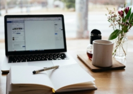 working at a desk with laptop and notebook