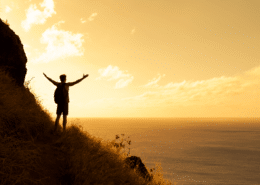 man standing on a clifftop at sunset